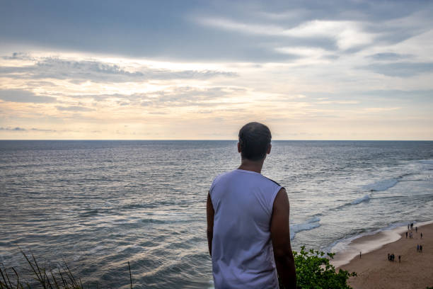 istock Isolated man watching a beautiful sunset over sea horizon. 1281059438