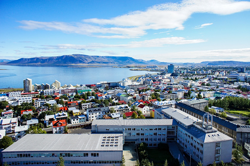 View of the multi-colored roofs of Rekjavik, the mountain and the blue cloudy sky. Scenery