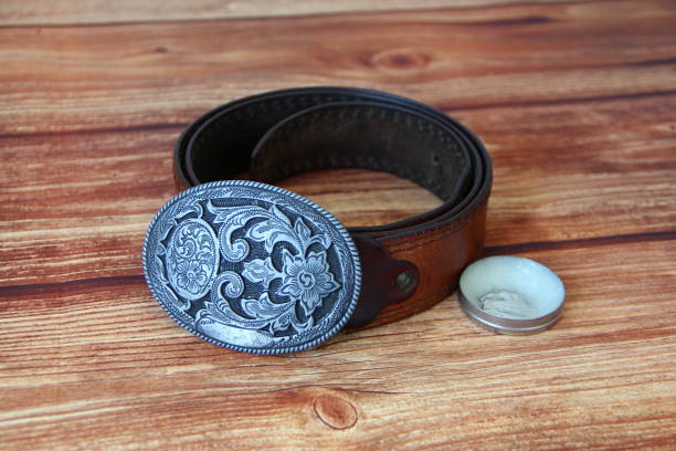 istock Leather cowboy belt with oval patterned buckle and cream for leather products 1281062829