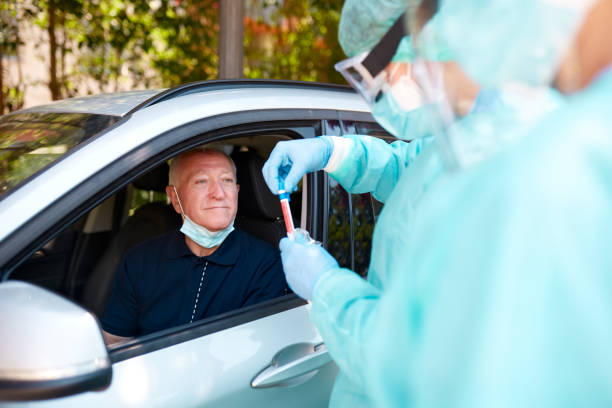 istock Senior Man Getting Nasal Swab Test at Drive-Thru 1281063406