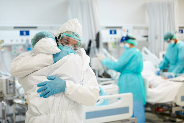 istock Health care workers in Protective Workwear Embracing in Support 1281064247