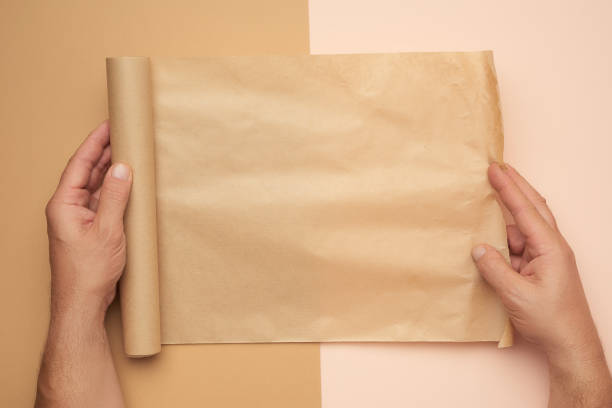 istock two male hands hold a roll of brown paper 1281067555