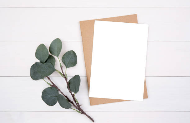 istock Blank paper sheet copy space with mockup and leaf on wooden table, poster and notebook, postcard decoration your design or branding, simplicity and minimal, nobody, flat lay, top view. 1281069091