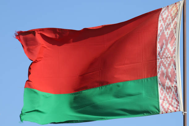 istock Belarusian flag flying on flagpole on blue sky background 1281070526