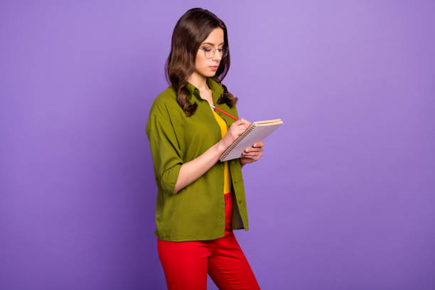 istock Portrait of focused smart girl high school student study remote write copybook lecture report wear pants isolated over purple color background 1281071838