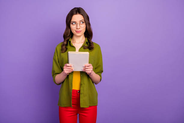 istock Portrait of minded thoughtful girl hipster hold note book think thoughts decide subject diary project wear style stylish trendy red pants trousers isolated violet color background 1281072036
