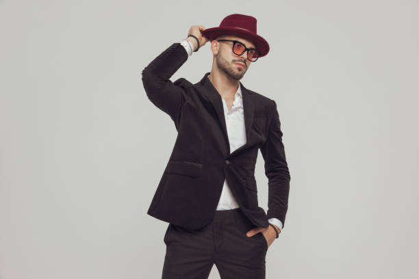 istock Confident fashion model fixing hat with hand in pocket 1281076205