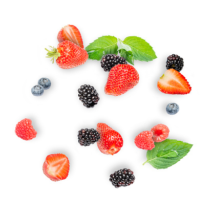 Mix the berries with the leaves. Various fresh berries isolated on a white background. Raspberries, blueberries, blackberries and strawberries.