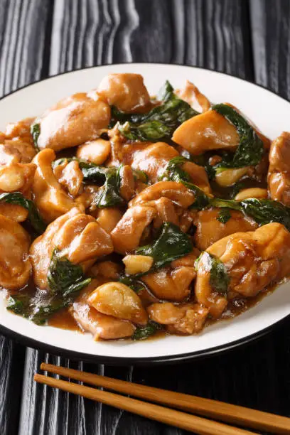 Photo of Sanbeiji is a popular chicken dish in Chinese cuisine closeup on the plate. Vertical