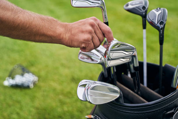 mężczyzna golfista przygotowuje się do treningu na świeżym powietrzu - golf green practicing sports training zdjęcia i obrazy z banku zdjęć