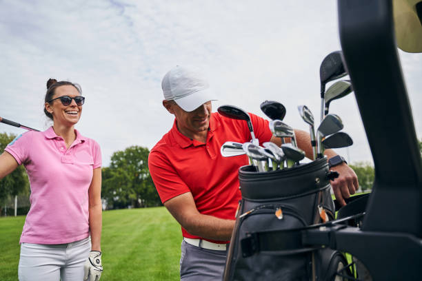 istock High-spirited sporty lady standing behind her golf instructor 1281079489