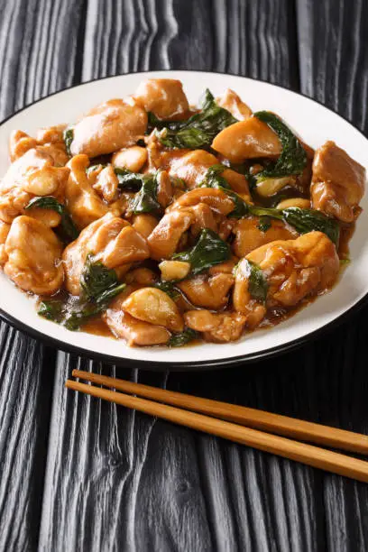 Photo of Three cup chicken, also known as Sanbeiji is an iconic chicken dish in Chinese cuisine, especially popular in Taiwan closeup on the plate. Vertical