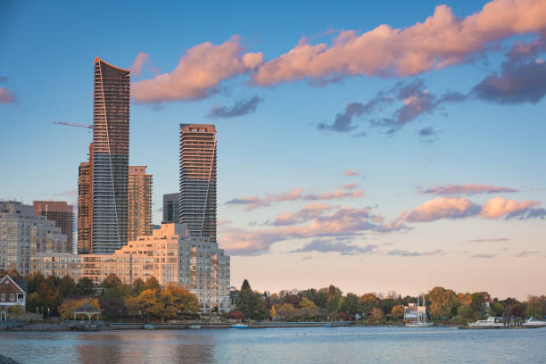 Residential towers along a lake. Residential towers against a sunset colored sky.  Clouds reflecting pink hues with a blue sky. etobicoke stock pictures, royalty-free photos & images