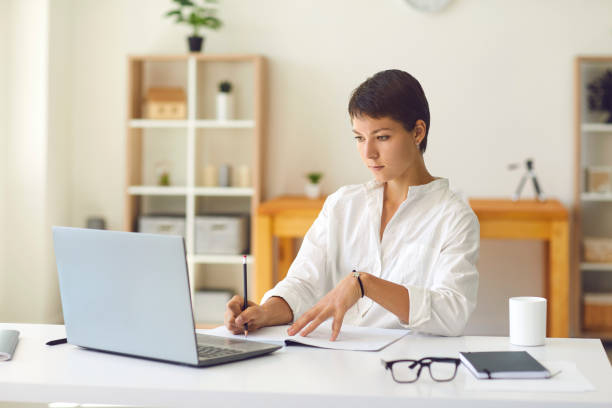 istock Smiling coach having online lesson with student or hosting webinar sitting at desk with laptop 1281082434