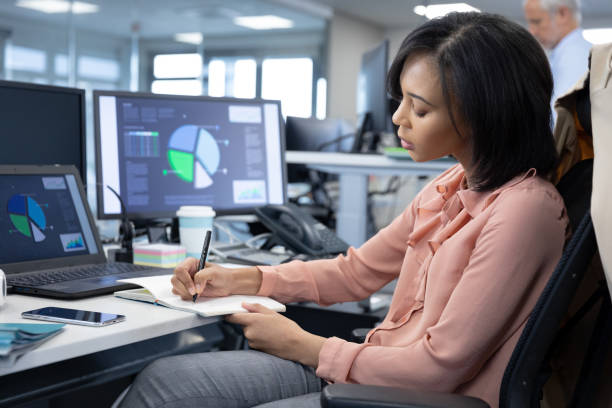 istock Businesswoman taking notes while sitting on her desk at modern office 1281085586