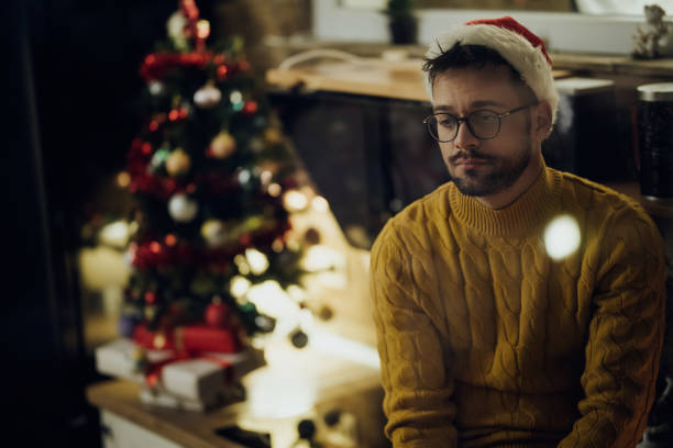Young sad man spending Christmas Eve alone at home.