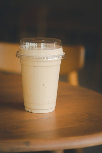 istock Close up milk coffee smoothie in plastic cup on wood table 1281085996