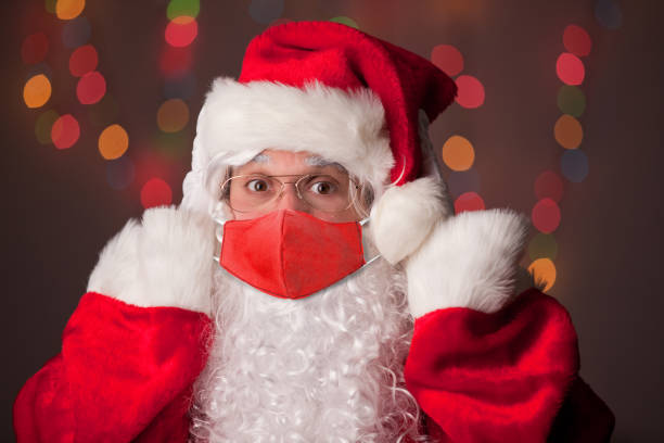 istock Santa Claus Putting Coronavirus Face Mask On 1281086014