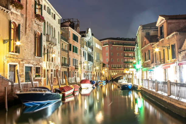istock Evening view of illuminated old architecture, floating boats and light reflections in canals water in Venice, Italy. 1281086727