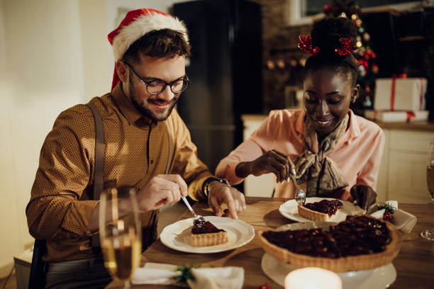istock Young happy couple having cranberry pie during Christmas dinner at home. 1281089068