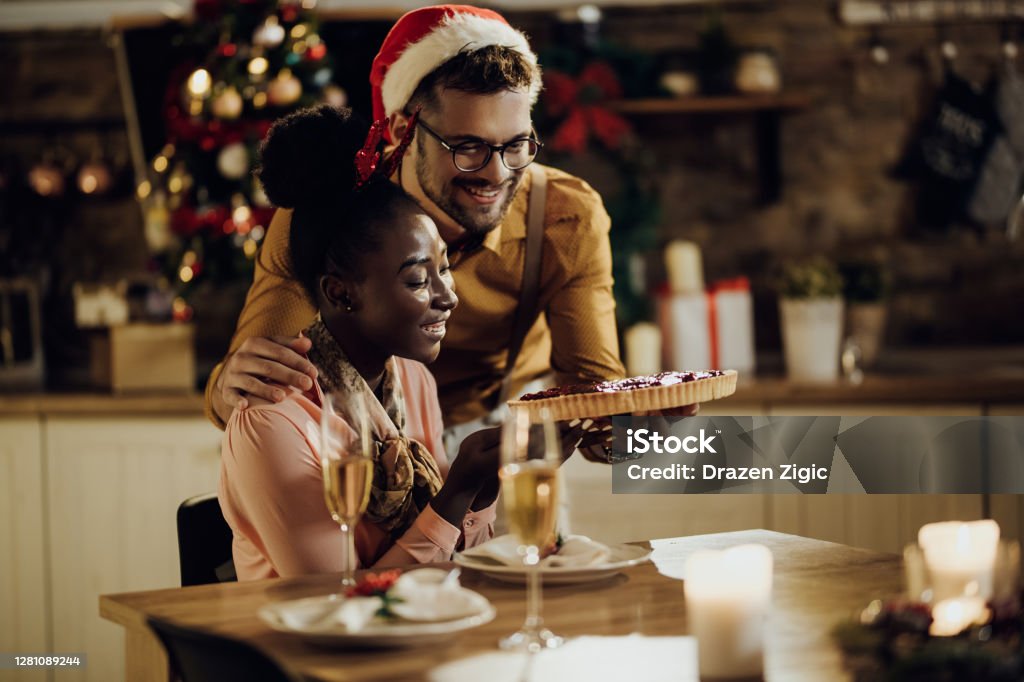 Evde Noel arifesini kutlarken kızılcık turtası olan genç mutlu çift. - Royalty-free Adamlar Stok görsel Evde Noel arifesini kutlarken kızılcık turtası olan genç mutlu çift. - Royalty-free Adamlar Stok görsel