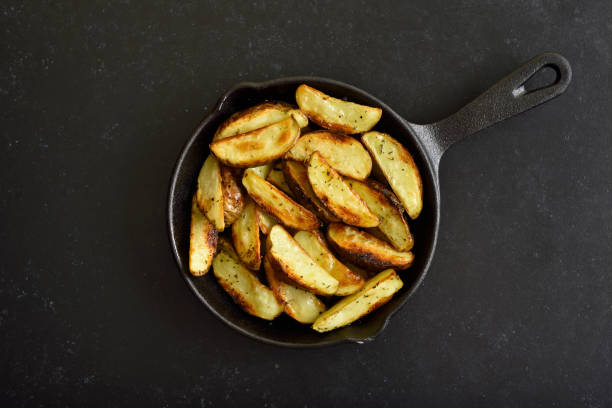 istock Fried potato wedges in frying pan 1281090745