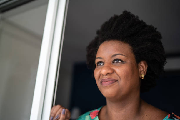 istock Thoughtful woman looking through the window at home 1281090903