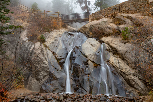 Hellen Hunt water fall in Colorado Springs Colorado USA. Unusual thick daytime fog on cold late autumn day. Long exposure.