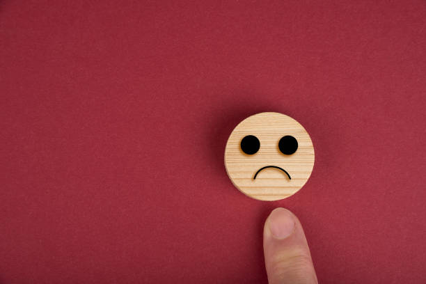 istock Sad smiles on a wood circles on wood on a red 1281091829