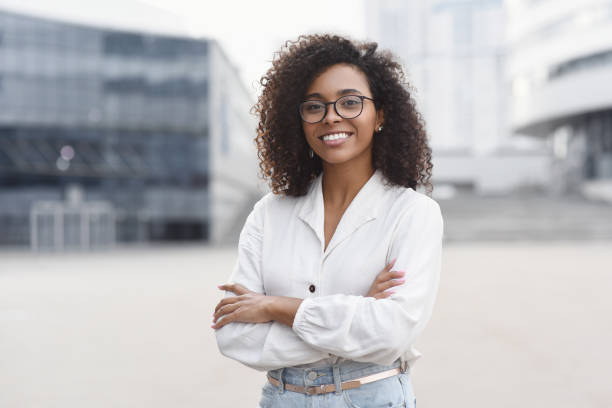 junge geschäftsfrau wih gekreuzte arme outdoor-porträt - businesswoman business women african descent stock-fotos und bilder