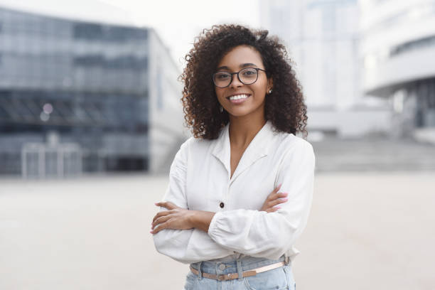 Young business woman wih crossed arms outdoor portrait Smiling african-american student girl in a city. Woman looking at camera. People, city life, student lifestyle concept african american ethnicity stock pictures, royalty-free photos & images