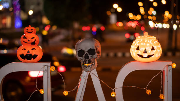 istock Pumpkins and skulls with beautiful lights and blurred background. 1281093430