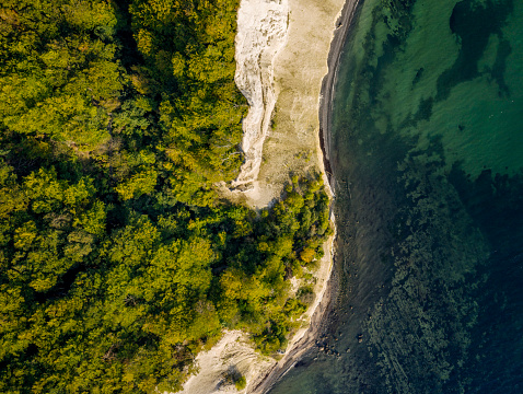 Drone’s eye view looking straight down to the water’s edge where the staircase of 497 reaches the bottom of the cliff. Photographed in th early autumn on the island of Moen in Denmark.