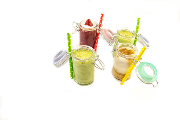 Freshly blended fruit smoothies of various colors and tastes in glass jars. Yellow, red, green.