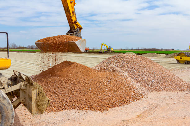 istock Backhoe is taking gravel from pile at construction site 1281094056