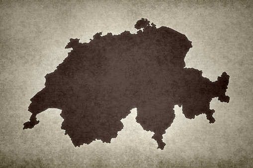Grunge map of Switzerland with its flag printed within its border on an old paper.
