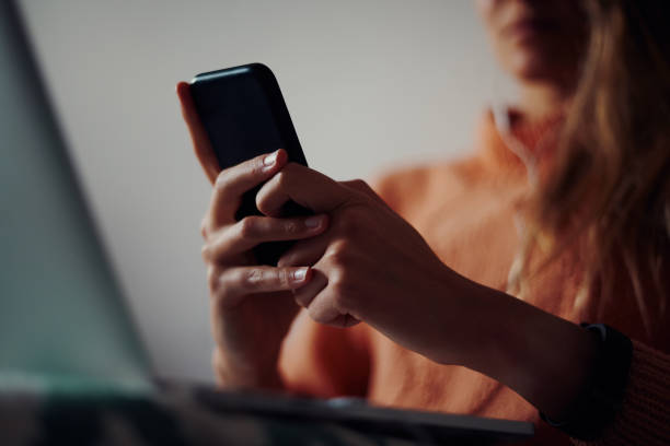 istock Closeup of young woman hands holding and using smartphone at home during quarantine 1281096782