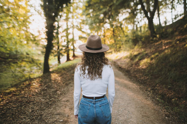 istock Rear view of young woman with hat at forest 1281097980