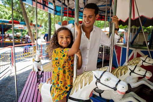 Adventure awaits as a child sets off on a round and round escapade, riding on motorized vehicles and immersing themselves in the excitement of the amusement park