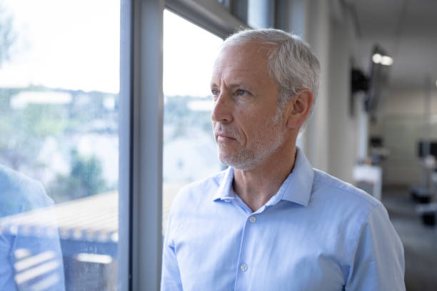 istock Senior businessman looking through window at modern office 1281099723