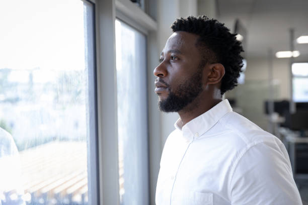 istock Businessman looking through window at modern office 1281099952