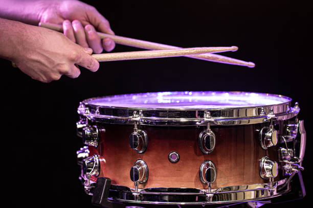 istock Drummer hitting drumsticks on snare drum on black background close up. 1281100131