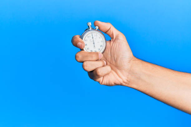 istock Hand of young hispanic man using stopwatch over isolated blue background. 1281100681