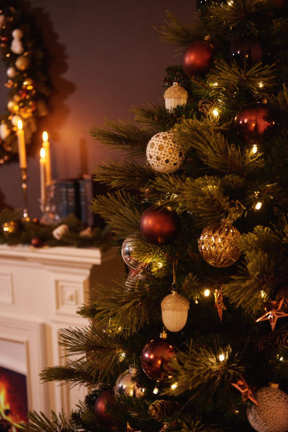 istock Bright christmas toy hanging on a green tree, blurred warm background 1281104834
