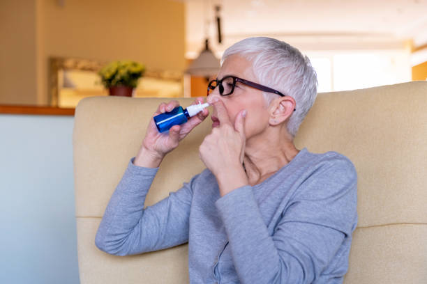 istock Senior woman taking nose drops at home 1281108749