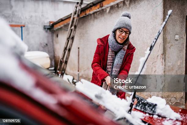 Mujer Limpiando Nieve De Su Coche Foto de stock y más banco de imágenes de Coche - Coche, Invierno, Nieve