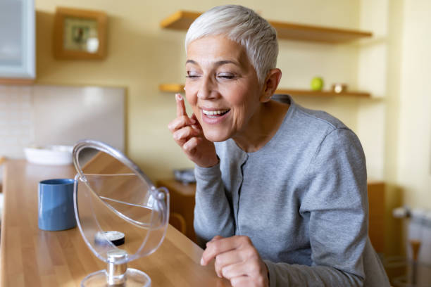 istock Mature woman applying anti-aging cream on her face 1281110457