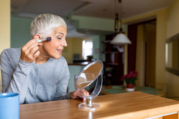 istock Senior Woman Doing Makeup In Front Of Mirror 1281110645