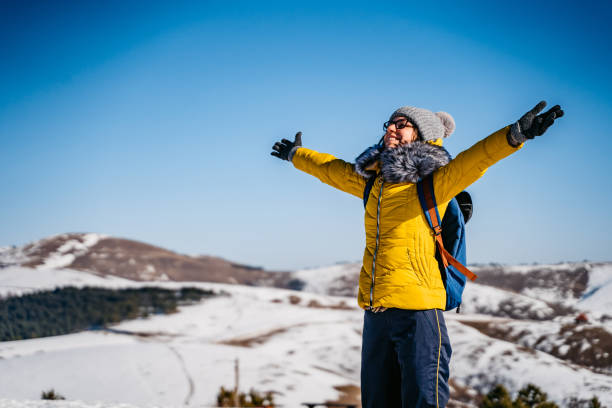 istock Woman with open arms on snowy mountain 1281110681