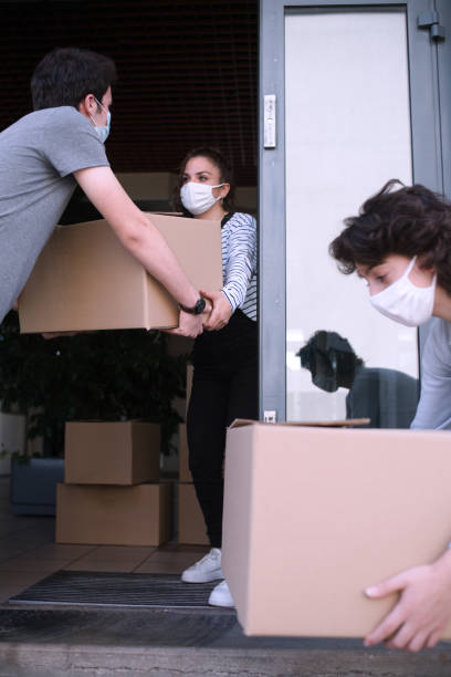 istock in front of a building door 3 young people carry boxes 1281110700